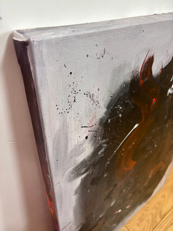 Close-up of a textured abstract canvas with black, gray, and reddish-brown paint marks and splatter details.