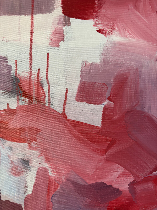Close-up of a contemporary abstract painting with soft pink, red, and mauve layers, white negative space, and fine red drips.