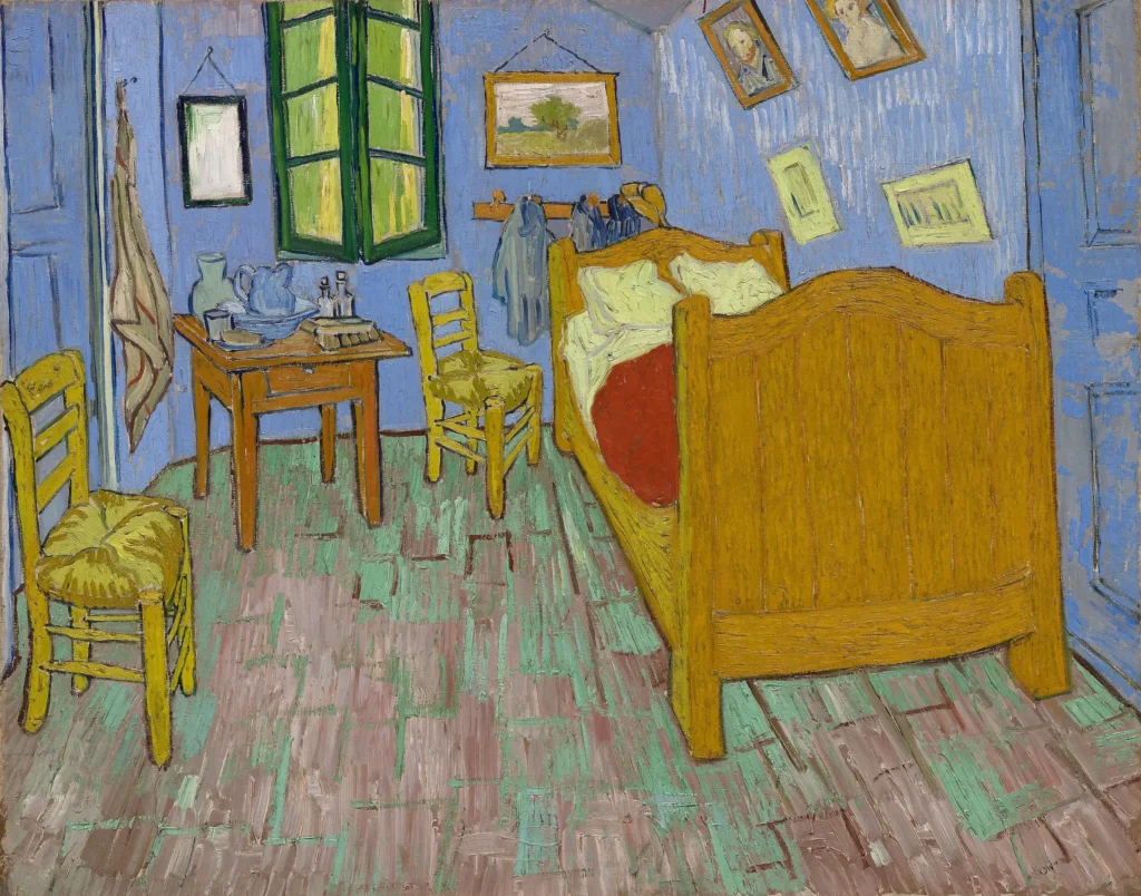 Van Gogh’s The Bedroom, showing blue walls, a wooden bed with a red blanket, two chairs, and a small table.